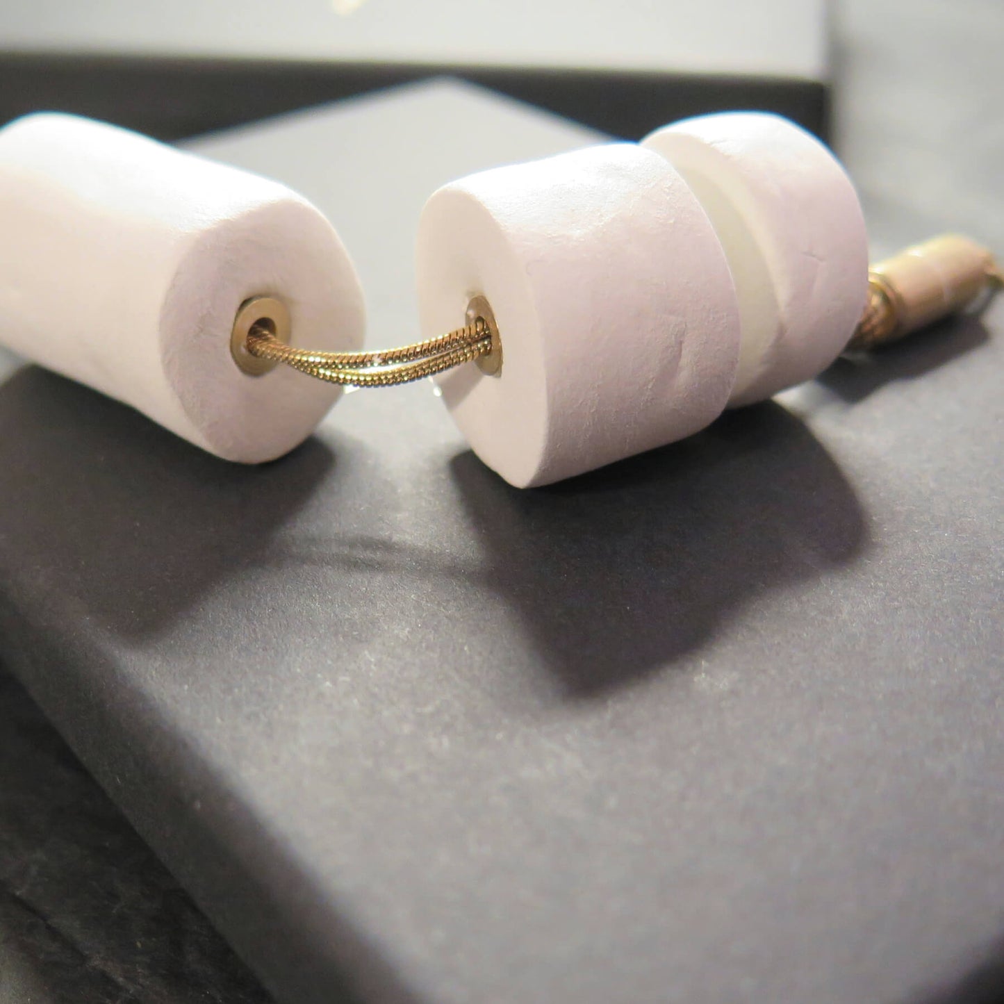 Stacked white stone tubular beads on adjustable gold snake chain necklace with brass detailing