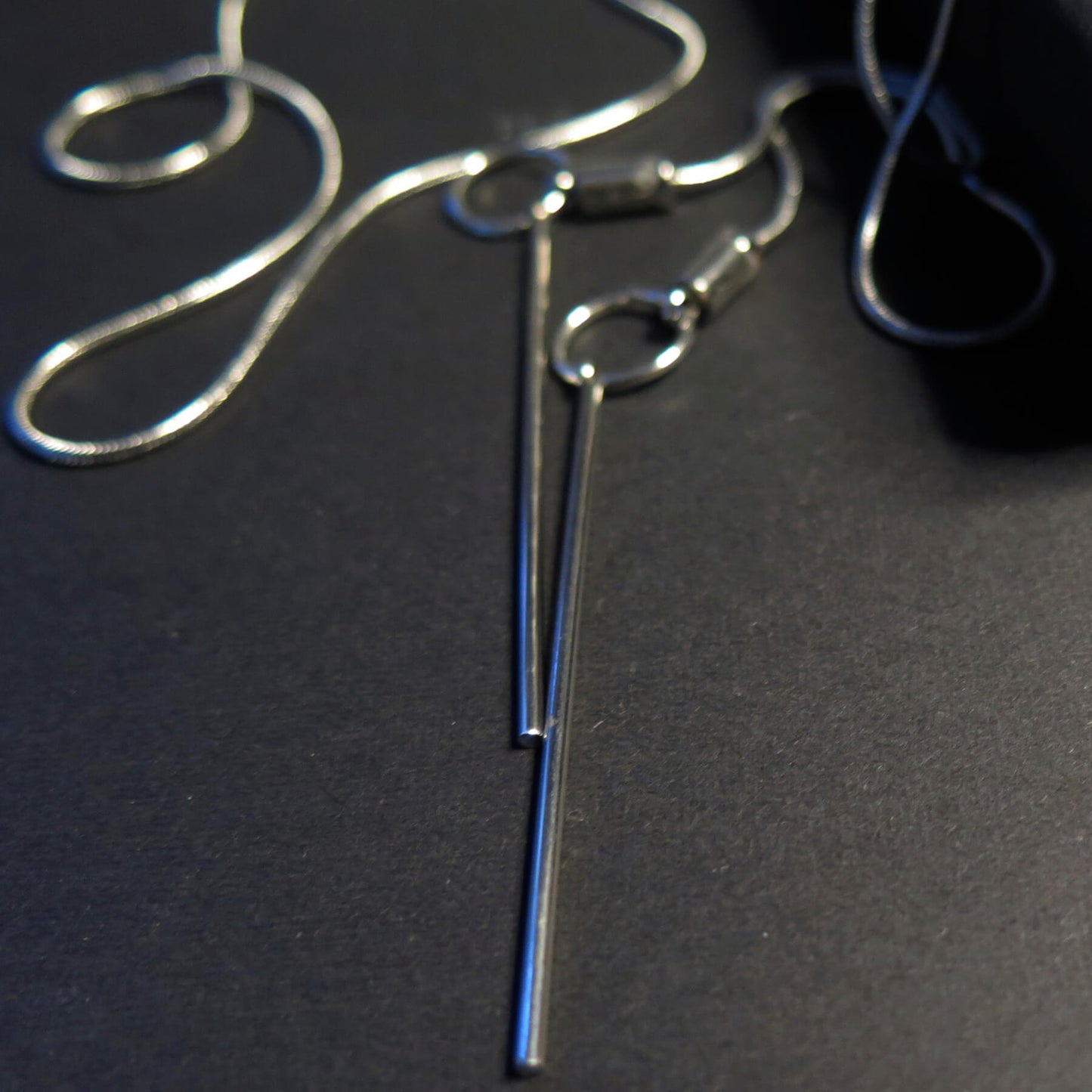 Sculpted light grey pebble on adjustable length silver snake chain necklace with bar pendant ends
