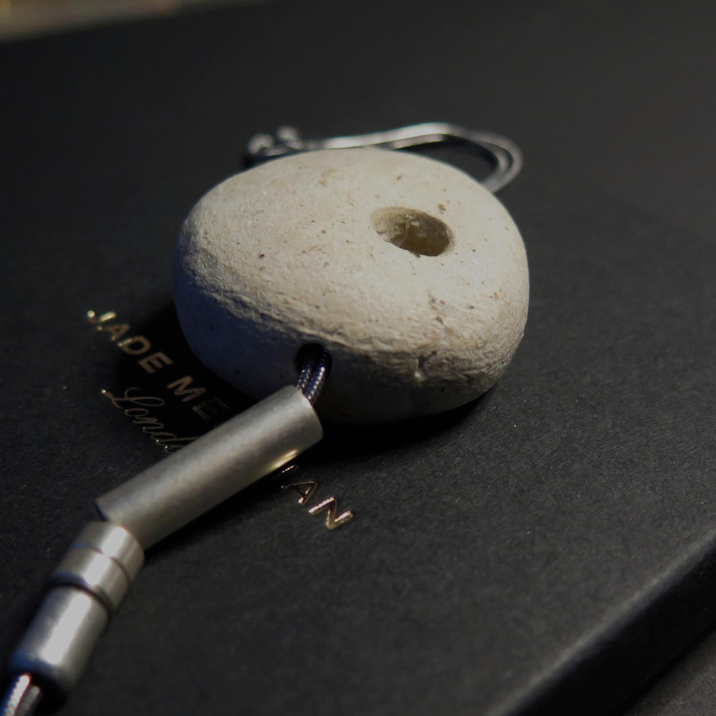 Sculpted light grey pebble on adjustable length silver snake chain necklace with bar pendant ends