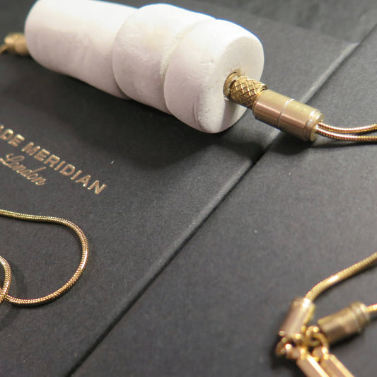 Stacked white stone tubular beads on adjustable gold snake chain necklace with brass detailing