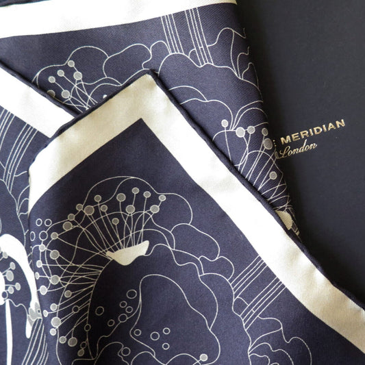 Pure silk scarf with hand rolled edge with a deep blue and white gold pattern on a bespoke black gift box with gold foil logo